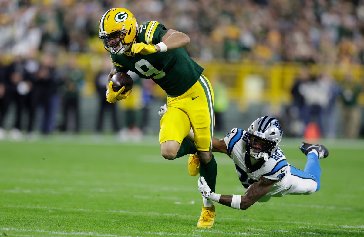 Green Bay Packers wide receiver Christian Watson (9) is hit by Carolina Panthers safety Zakee Wheatley as he catches a pass for a first down during the first half of an NFL football game in Green Bay, ...