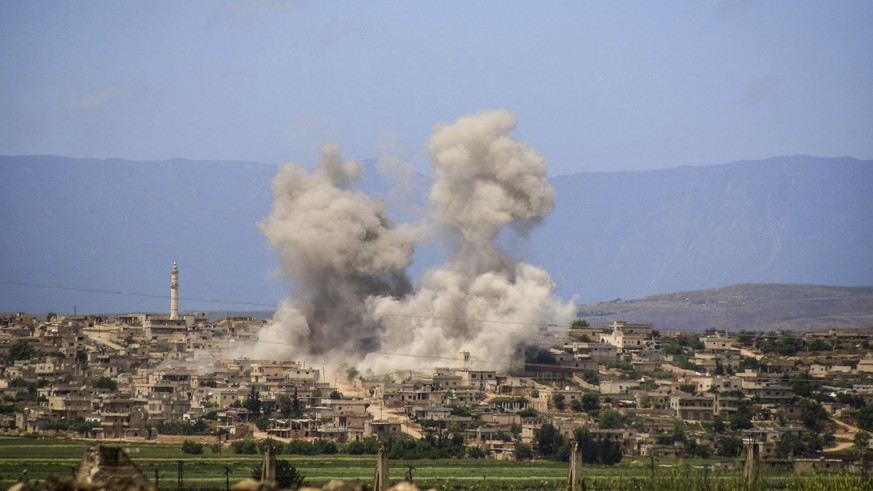 This photo provided by the Syrian Civil Defense White Helmets, which has been authenticated based on its contents and other AP reporting, shows smoke rises after Syrian government and Russian airstrik ...