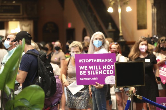 Opponents of a total ban on abortion gather in the lobby of the South Carolina Statehouse on Tuesday, Aug. 30, 2022, in Columbia, S.C. (AP Photo/Jeffrey Collins)