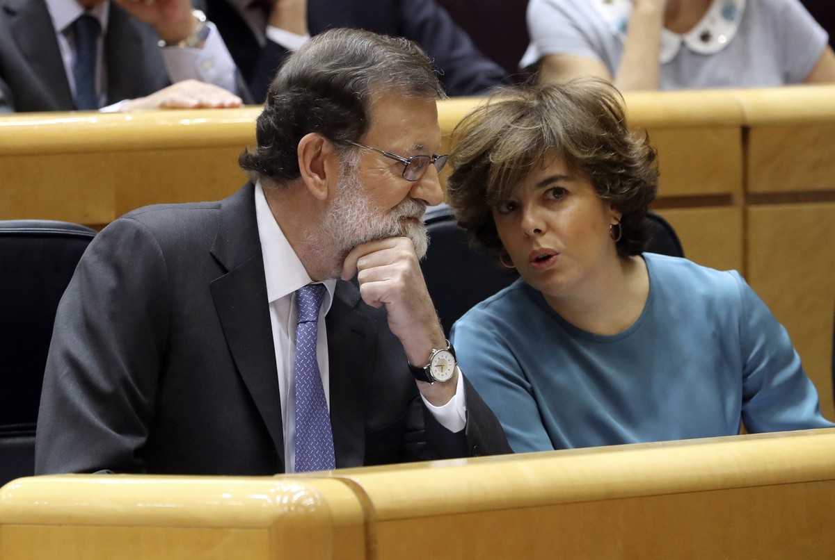 epa06292104 Spanish Prime Minister, Mariano Rajoy (L), chats with Vice Prime Minister, Soraya Saez de Santamaria, prior to the start of the Senate's extraordinary plenary session on the applicati ...