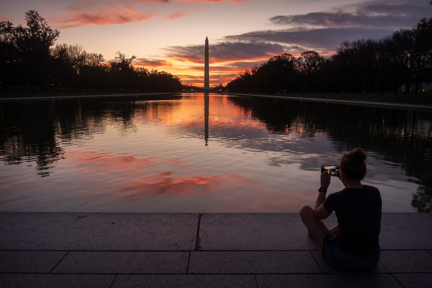 A visitor sits along the reflecting pool near the Washington Monument at dawn on Wednesday, Oct. 1, 2025, in Washington. (AP Photo/Mark Schiefelbein)
Congress Shutdown