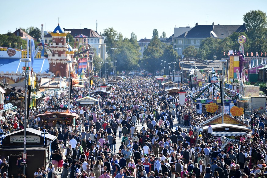 epa07858481 People walk across the grounds prior to the opening of the 186th Oktoberfest beer festival on the Theresienwiese in Munich, Germany, 21 September 2019. The Munich Beer Festival is the worl ...