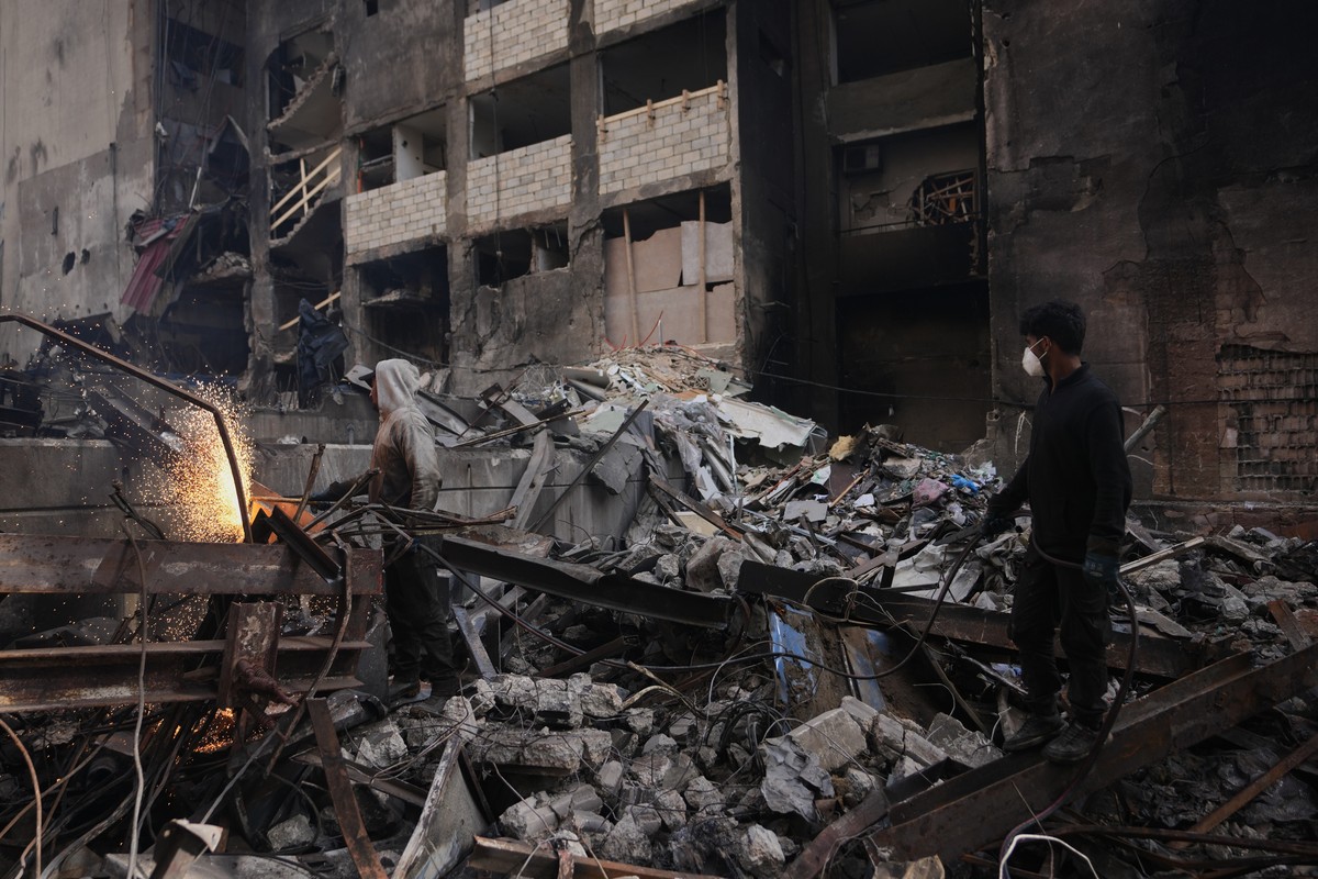 KEYPIX - A worker cuts scrap metal as sparks fly amid debris at the site of a building destroyed in an Israeli airstrike last Wednesday in central Beirut, Lebanon, Tuesday, April 14, 2026. (AP Photo/H ...