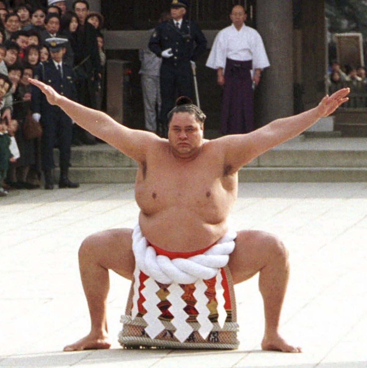 FILE - Accompanied by a sword-bearer, grand champion Akebono performs the ring-entrance ritual during the annual New Year's dedication at Meiji Shrine in Tokyo, on Jan. 8, 1997. Hawaii-born Akebo ...