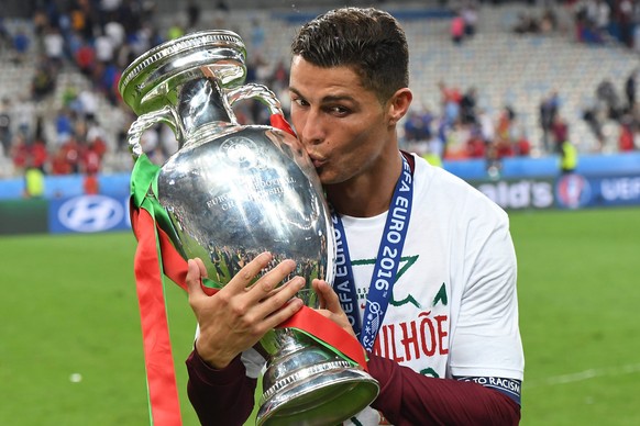 ARCHIV - ZUM RUECKBLICK AUF DIE EM 2016 STELLEN WIR IHNEN FOLGENDES BILDMATERIAL ZUR VERFUEGUNG - epa05419742 Cristiano Ronaldo of Portugal kisses the trophy after winning the UEFA EURO 2016 Final mat ...