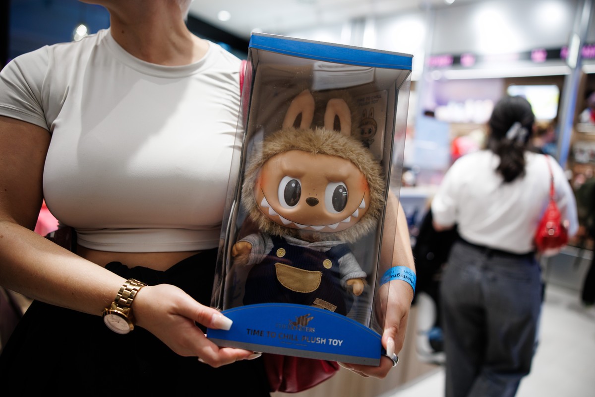 epa12261491 A customer holds a box with a toy figure in the first Pop Mart store selling Labubu toys in Berlin, Germany, 25 July 2025. Labubus are collectible plush toys and characters in the series & ...