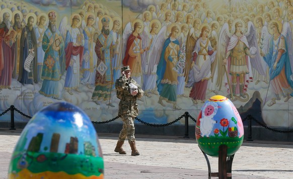 epa05904344 Ukrainian serviceman carries an Easter cake in front of Mykhailovskiy Cathedral frescos during Easter eggs (Pysanka) festival in Kiev, Ukraine, 12 April 2017. Ukrainians will mark Orthodox ...