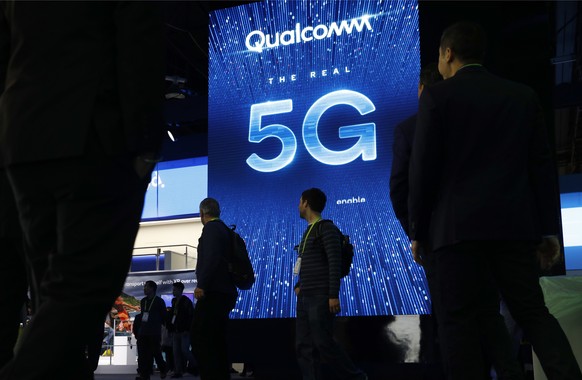 FILE- In this Jan. 9, 2019, file photo a sign advertises 5G at the Qualcomm booth at CES International in Las Vegas. Apple and mobile chip maker Qualcomm have settled a bitter financial dispute center ...