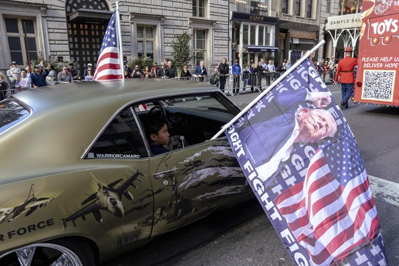 A boy holds a flag of U.S. President-elect Donald Trump during the annual Veterans Day Parade, Monday, Nov. 11, 2024 in New York. (AP Photo/Adam Gray)