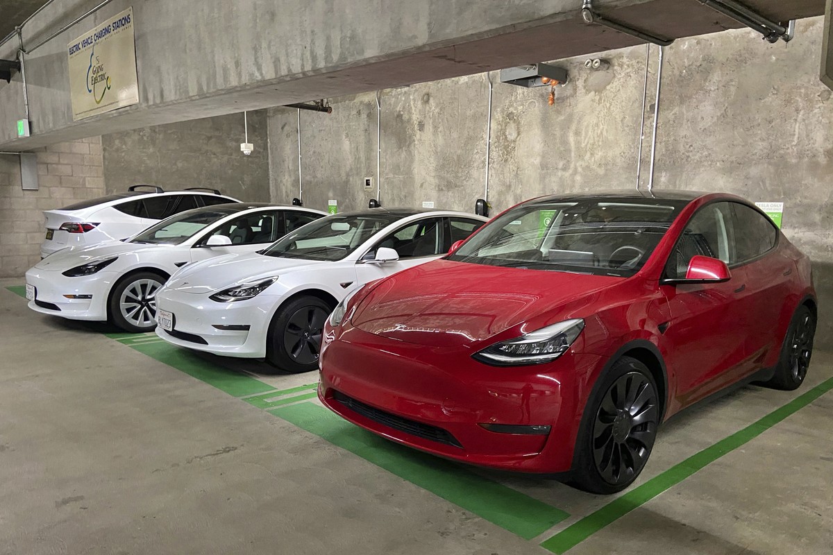 This photo provided by Edmunds shows a line of parked Tesla Model 3 and Model Y vehicles. The shopping and research process when buying your first used Tesla can be more involved than what's requ ...