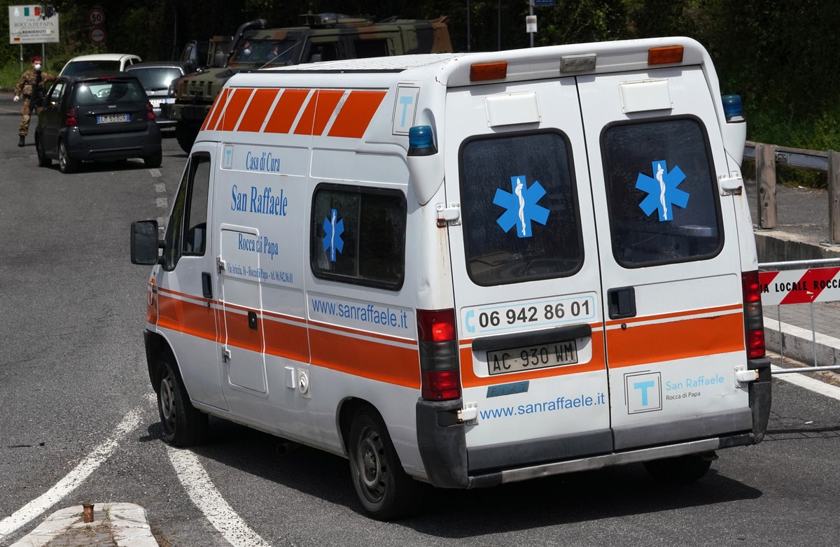 An ambulance of the San Raffaele health care and hospice structure drives past a road block on its way to the San Raffaele hospice after, according to reports, over 70 people inside tested positive to ...