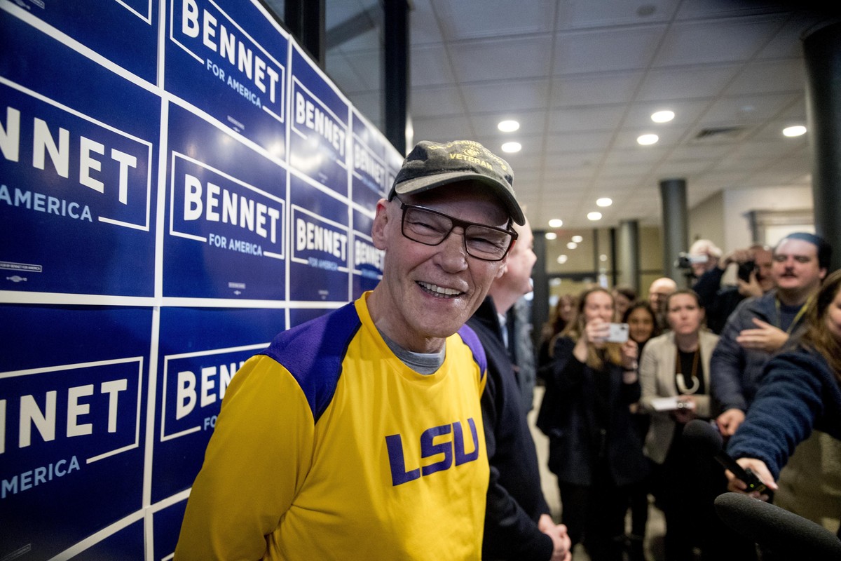 James Carville, a political commentator known for leading former President Bill Clinton's 1992 presidential campaign, smiles as Democratic presidential candidate Sen. Michael Bennet, D-Colo., bac ...