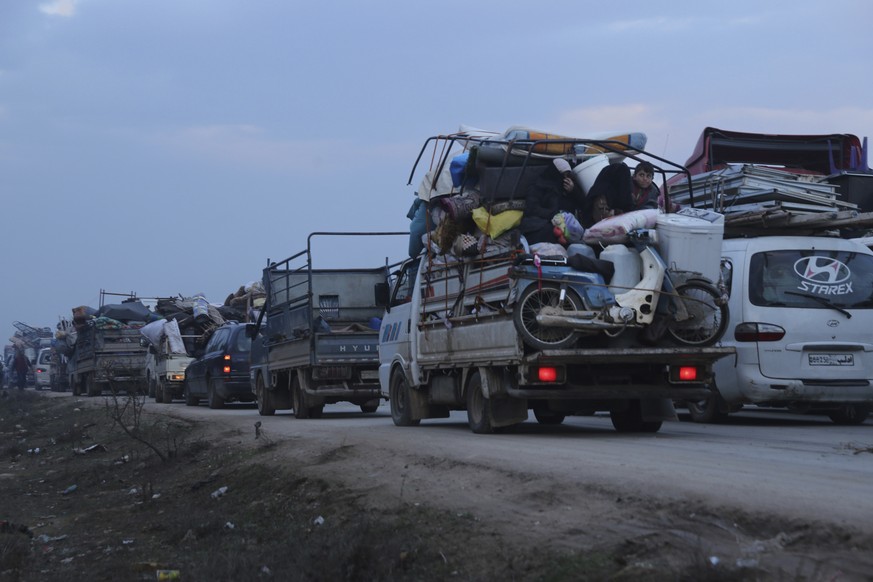 Truckloads of civilians flee a Syrian military offensive in Idlib province on the main road near Hazano, Syria, Tuesday, Dec. 24, 2019. Syrian forces launched a wide ground offensive last week into th ...