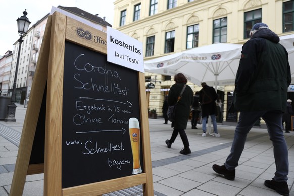 People pass the traditional Bavarian restaurant &#039;Hackerbraeuhaus&#039; where a corona test center now works for SARS CoV-2 rapid tests downtown in Munich, Germany, Tuesday, March 23, 2021. (AP Ph ...