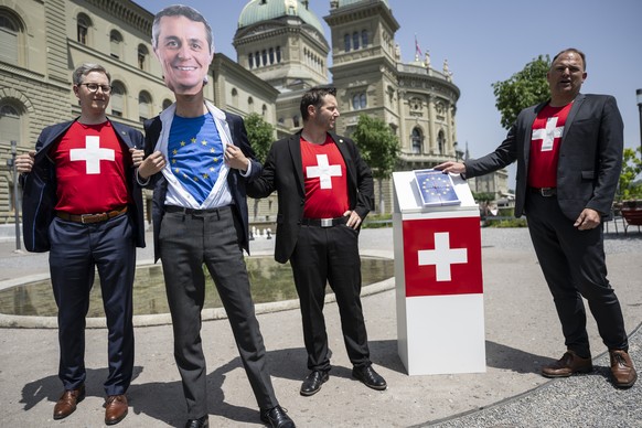 Die SVP Nationalraete Marcel Dettling, SZ, SVP Praesident, Yvan Pahud, VD, und Paolo Pamini, TI, von rechts, zusammen mit einem Kollegen, der eine Maske von Bundesrat Ignazio Cassis traegt, inszeniere ...