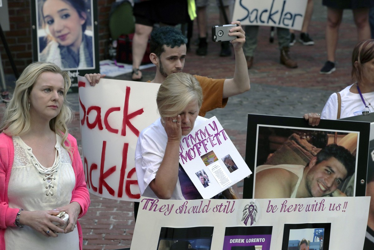 Protesters, including Carol Lorento, center, gather outside a courthouse on Friday, Aug. 2, 2019, in Boston, where a judge was to hear arguments in Massachusetts' lawsuit against Purdue Pharma ov ...