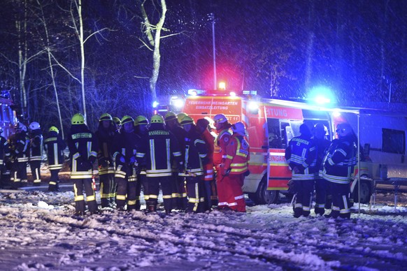 Emergency workers gather near the site where a plane crashed in Sieberatsreute near Ravensburg, southern Germany, Thursday, Dec. 14, 2017. Police said that three people were aboard the Cessna aircraft ...