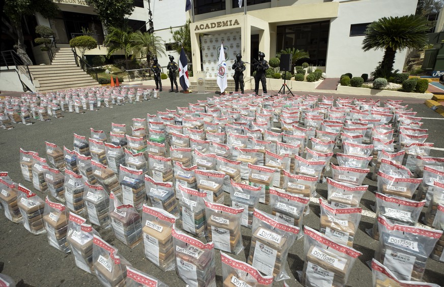 epa10554204 Members of Dominican National Direction of Drugs Control (DNCD) guard packages of cocaine from a two tons shipment seized, in Santo Domingo, Dominican Republic, 01 April 2023. The drug ori ...