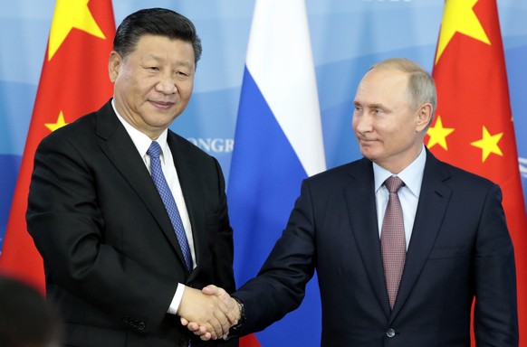 Russian President Vladimir Putin, right, shakes hands with Chinese President Xi Jinping during a signing ceremony following their talks at the Eastern Economic Forum in Vladivostok, Russia, Tuesday, S ...