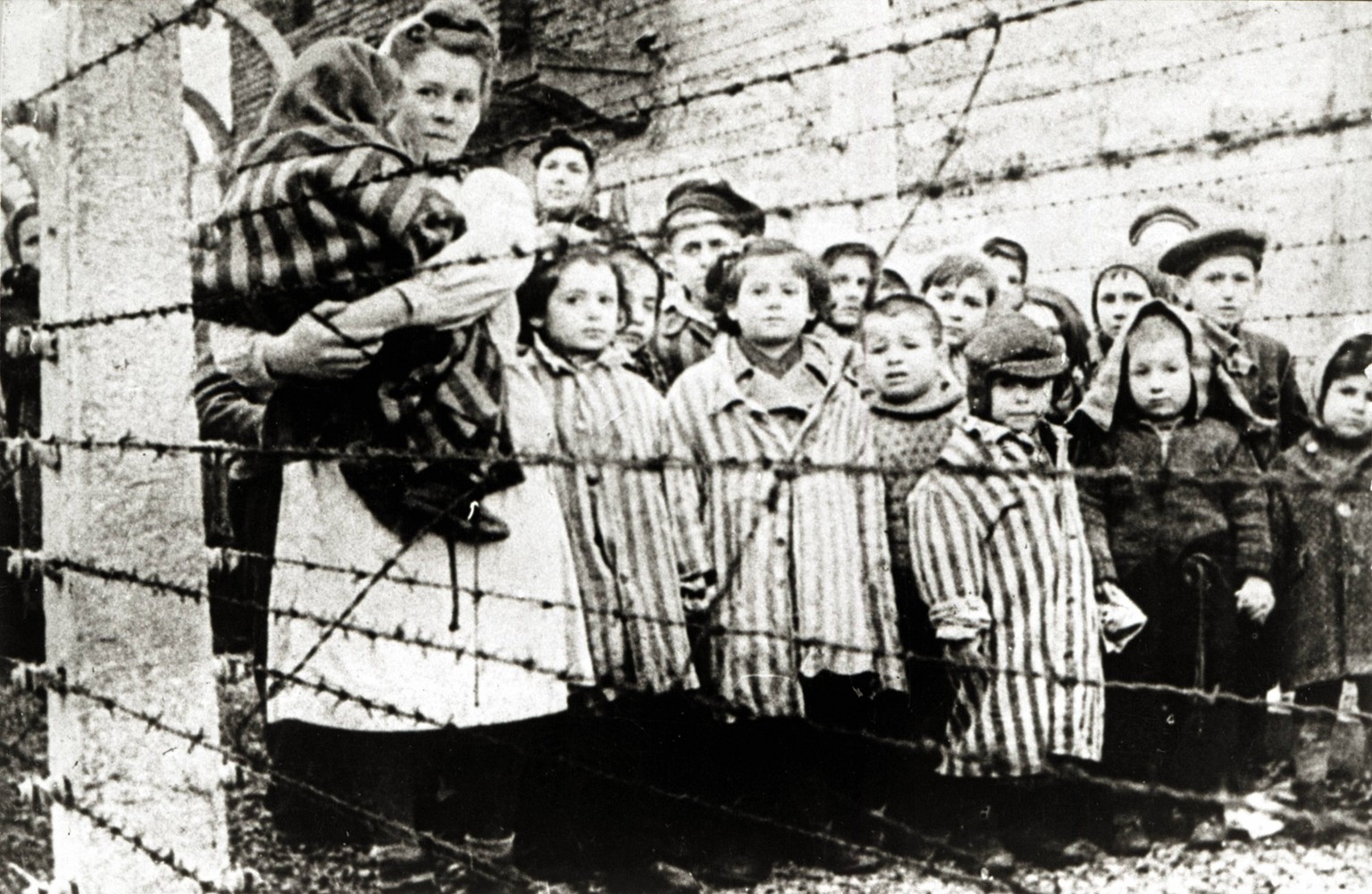 �berlebende j�dische Kinder in Auschwitz Mit Krankenschwester hinter Stacheldrahtzaun. Das Foto wurde von einem sowjetischen Fotografen w�hrend der Herstellung eines Films �ber Befreiung des Lagers ge ...