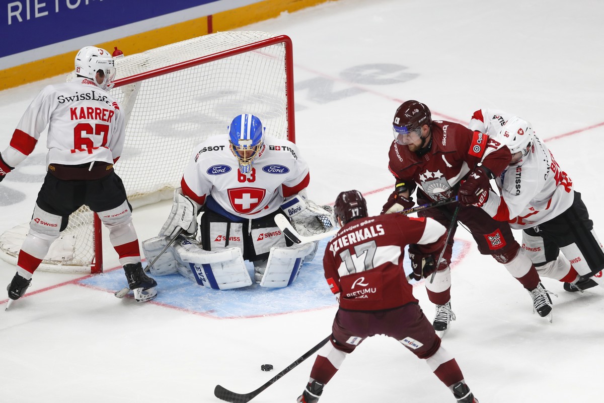 epa12055162 Latvia's Martins Dzierkals and Rihards Bukarts (2R) in action against Switzerland's goalkeeper Leonardo Genoni, Roger Karrer (L) and Tim Berni (R) during the friendly internation ...