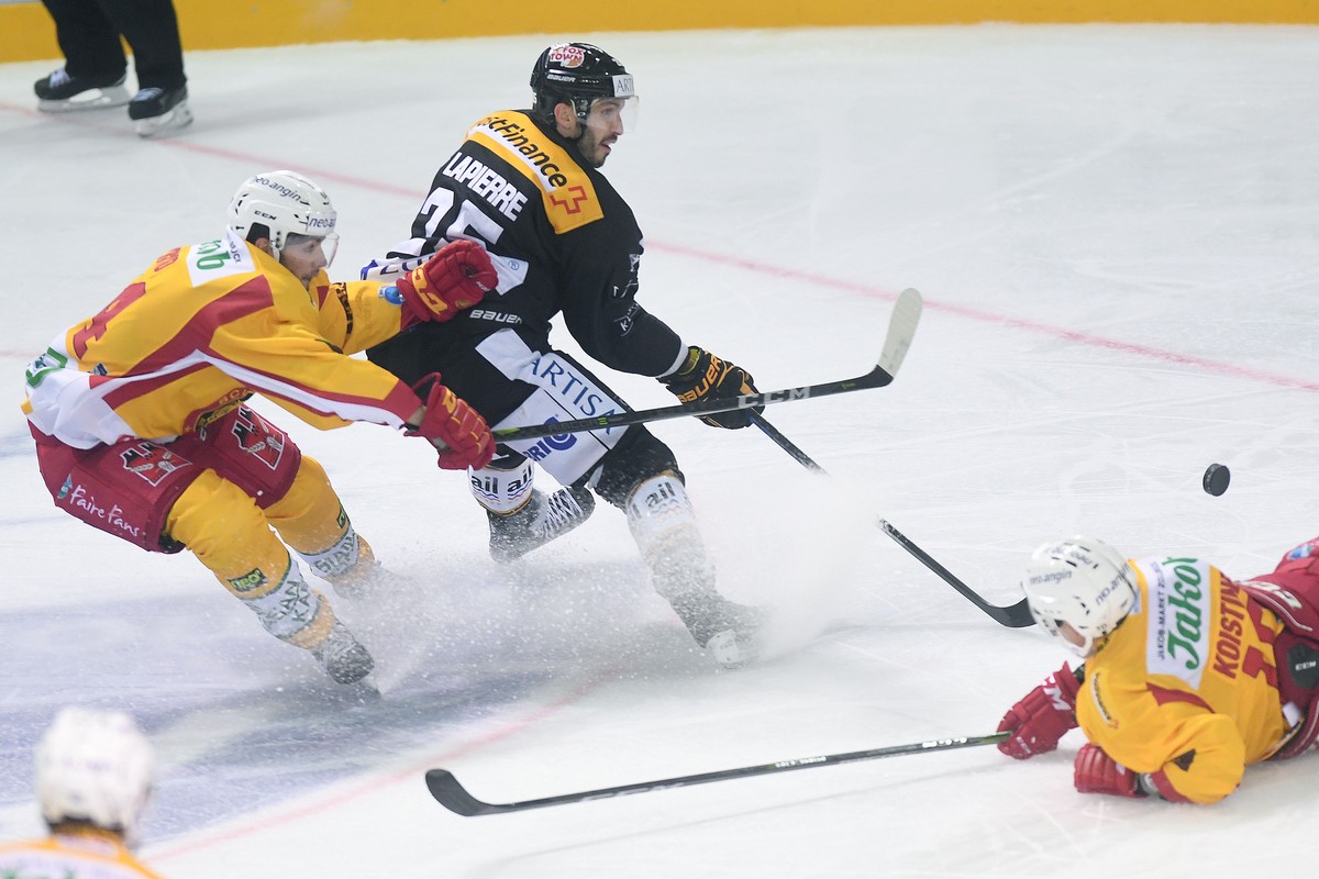 From left: Tiger's player Miro Zryd, Lugano’s player Maxim Lapierre and Tiger's player Ville Koistinen during the preliminary, round game of National League A (NLA, LNA) Swiss Championship 2 ...