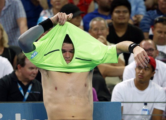 Milos Raonic of Canada changes shirts during a break in play during the men&#039;s singles final match against Roger Federer of Switzerland at the Brisbane International tennis tournament in Brisbane, ...