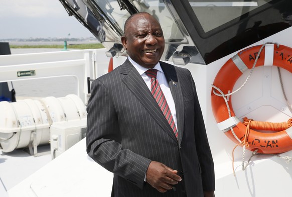 epa09618910 South African President Cyril Ramaphosa aboard a boat during a visit to the Autonomous Port in Abidjan, Ivory Coast, 03 December 2021. South African President Cyril Ramaphosa arrived in Ab ...