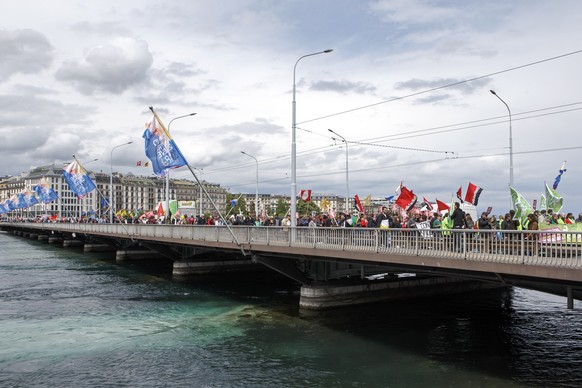 Des manifestants avec des pancartes et des drapeaux defilent sur le pont du Mont-Blanc, lors du defile du 1er mai - Fete du Travail, ce mardi 1 mai 2018 a Geneve. A Geneve, pres de 2&#039;000 personne ...