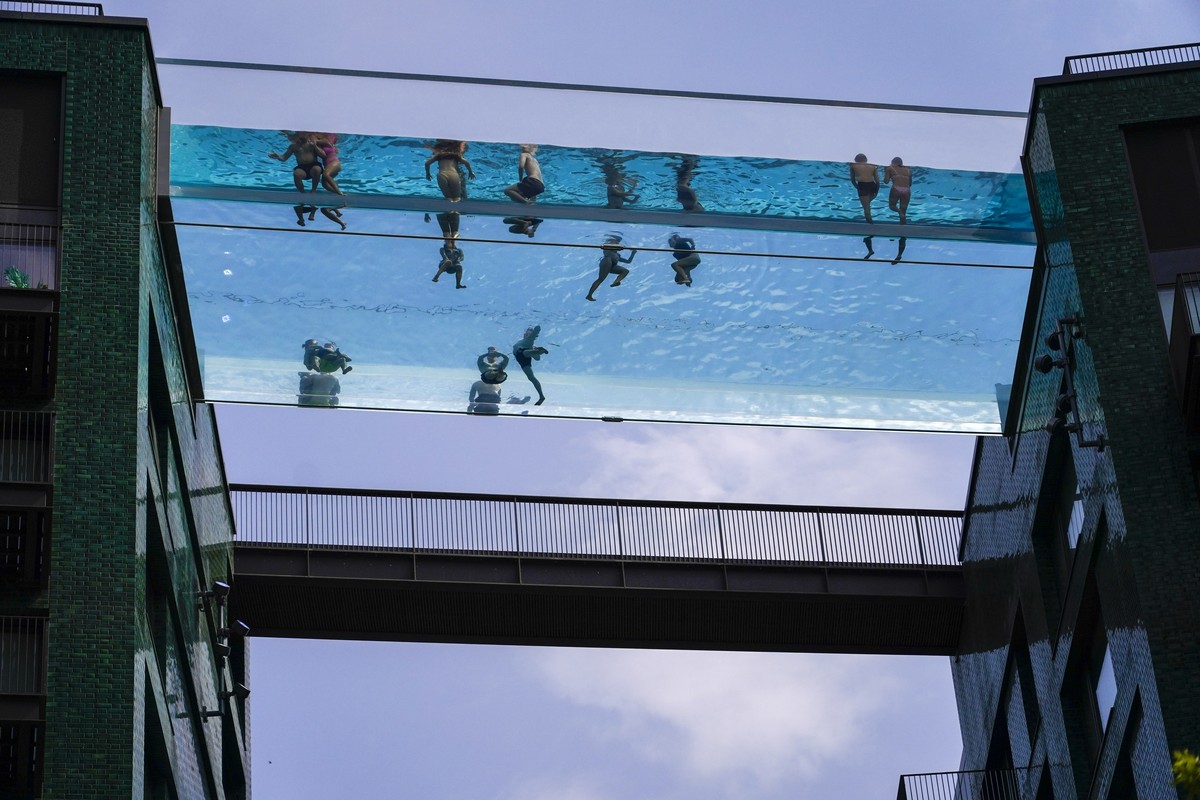 People swim in the elevated pool, called Sky Pool, in London, Monday, July 18, 2022. Britain's first-ever extreme heat warning is in effect for large parts of England as hot, dry weather that has ...