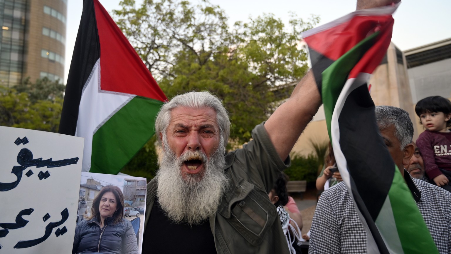 epa09942795 Lebanese and Palestinian activists carry Palestinian flags and posters of journalist Shireen Abu Akleh as they shout slogans during a protest against the killing of Al Jazeera journalist S ...