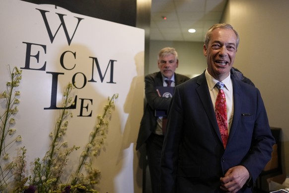 Former MEP and Honorary President of the Reform UK party Nigel Farage, right, arrives for the National Conservatism conference in Brussels, Tuesday, April 16, 2024. (AP Photo/Virginia Mayo)