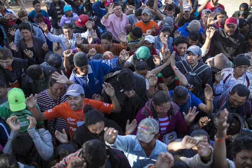 Central American migrants, part of the caravan hoping to reach the U.S. border, pray at a temporary shelter in Tijuana, Mexico, Friday, Nov. 16, 2018. As thousands of migrants of asylum-seekers conver ...