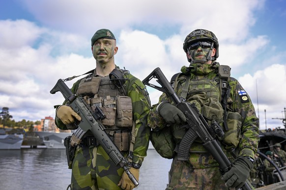 epa10597138 A Swedish and a Finnish soldier stand next to each other as Swedish amphibious soldiers practice together with Finnish amphibious soldiers from the Nylands brigade during the military exer ...