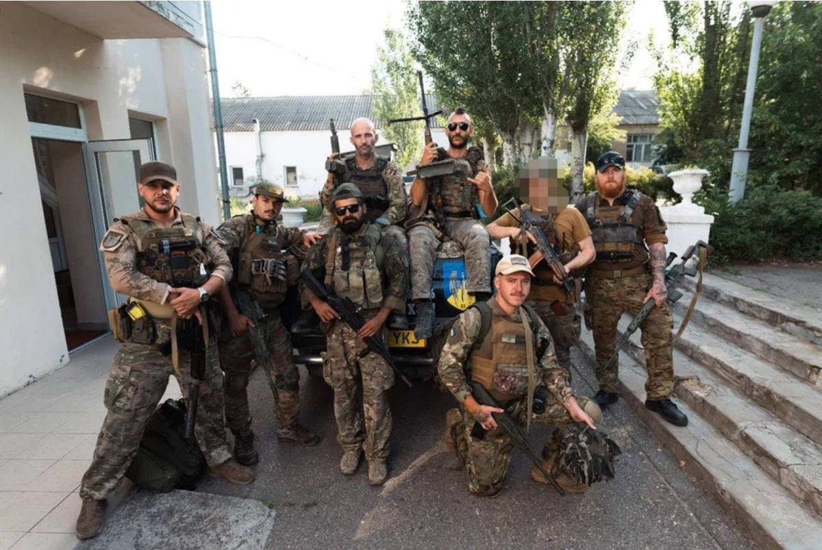 Maxime Barrat mit Sonnenbrille sitzt mit den Dark Angels auf dem Fahrzeug.