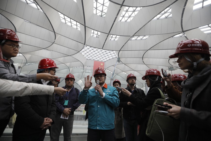 epa07405704 Media reporters gather to interview Li Jianhua (C), vice commander in chief of the Daxing International Airport project at the terminal hall of the new Beijing Daxing International Airport ...