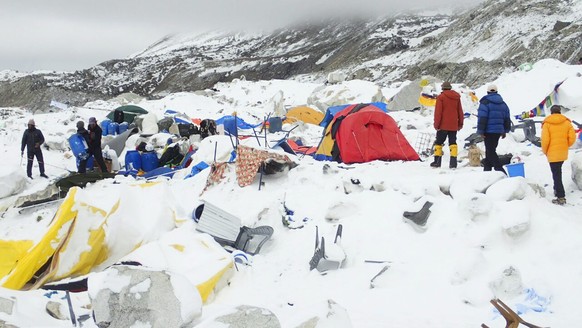 epa04721476 Dozens of tents lie damaged after an avalanche plowed through Mount Everest base camp, killing at least 18 people following the magnitude 7.9 earthquake in Nepal April 25, 2015 (photo taken ...