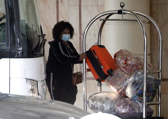 A coach delivers passengers to the Radisson Blu Edwardian Hotel, near Heathrow Airport, London, Monday Feb. 15, 2021 where they will remain during a 10 day quarantine period after returning to England ...