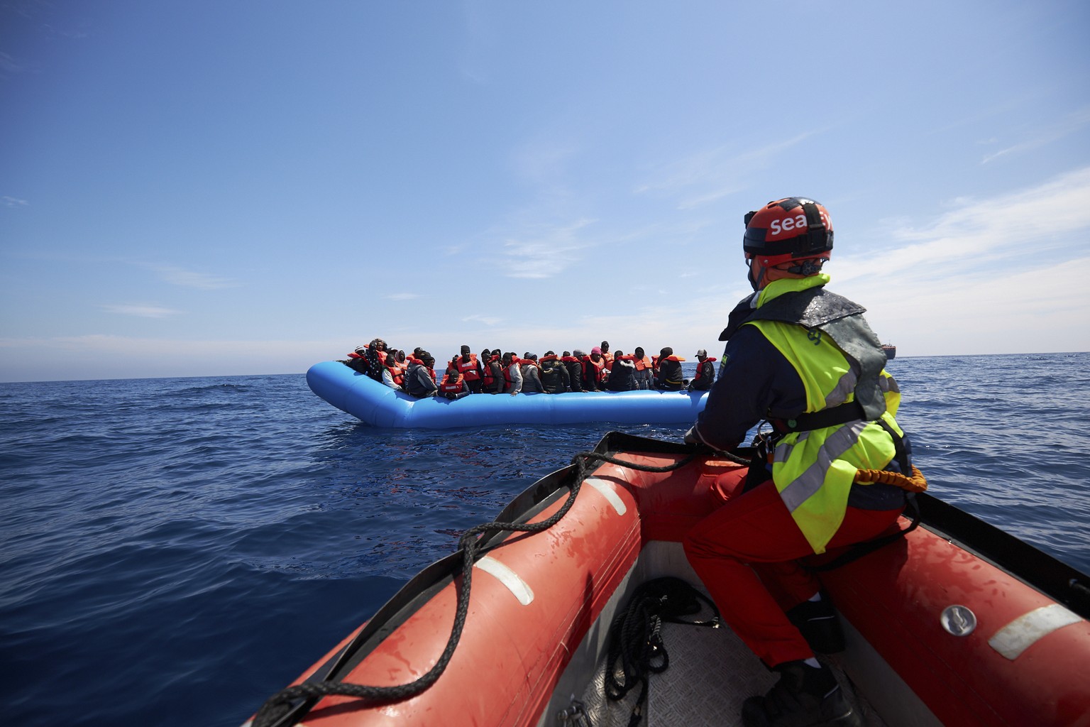 Ein Boot der Organisation Sea Eye nähert sich einem Schlauchboot mit Migranten. 