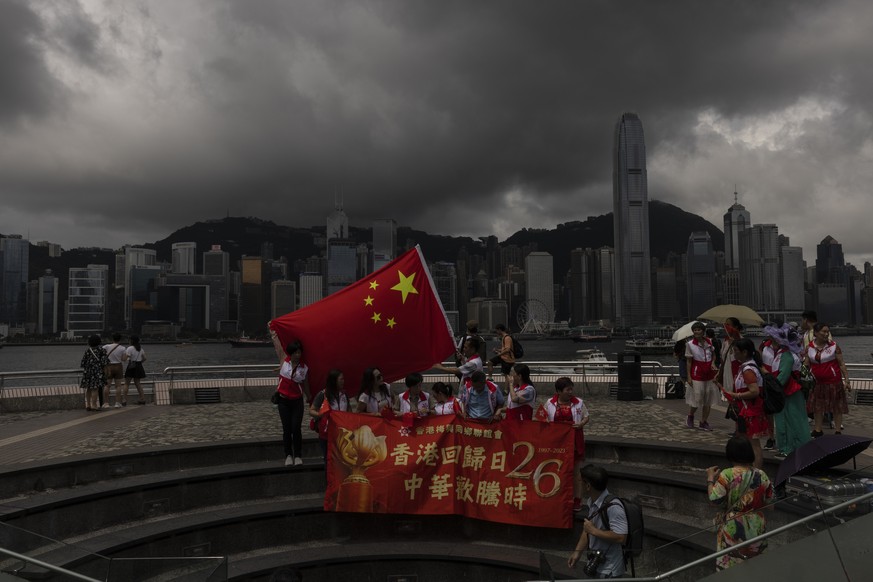Pro-Beijing supporters hold Chinese flags to mark the 26th anniversary of Hong Kong's return to Chinese rule, in Hong Kong, Saturday, July 1, 2023. (AP Photo/Louise Delmotte)