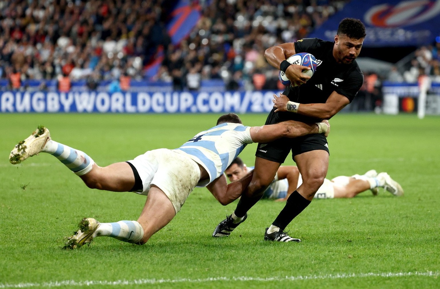 epa10929790 Richie Mo'unga (R) of New Zealand in action during the Rugby World Cup 2023 semi final match between Argentina and New Zealand in Saint-Denis, France, 20 October 2023. EPA/MOHAMMED BA ...