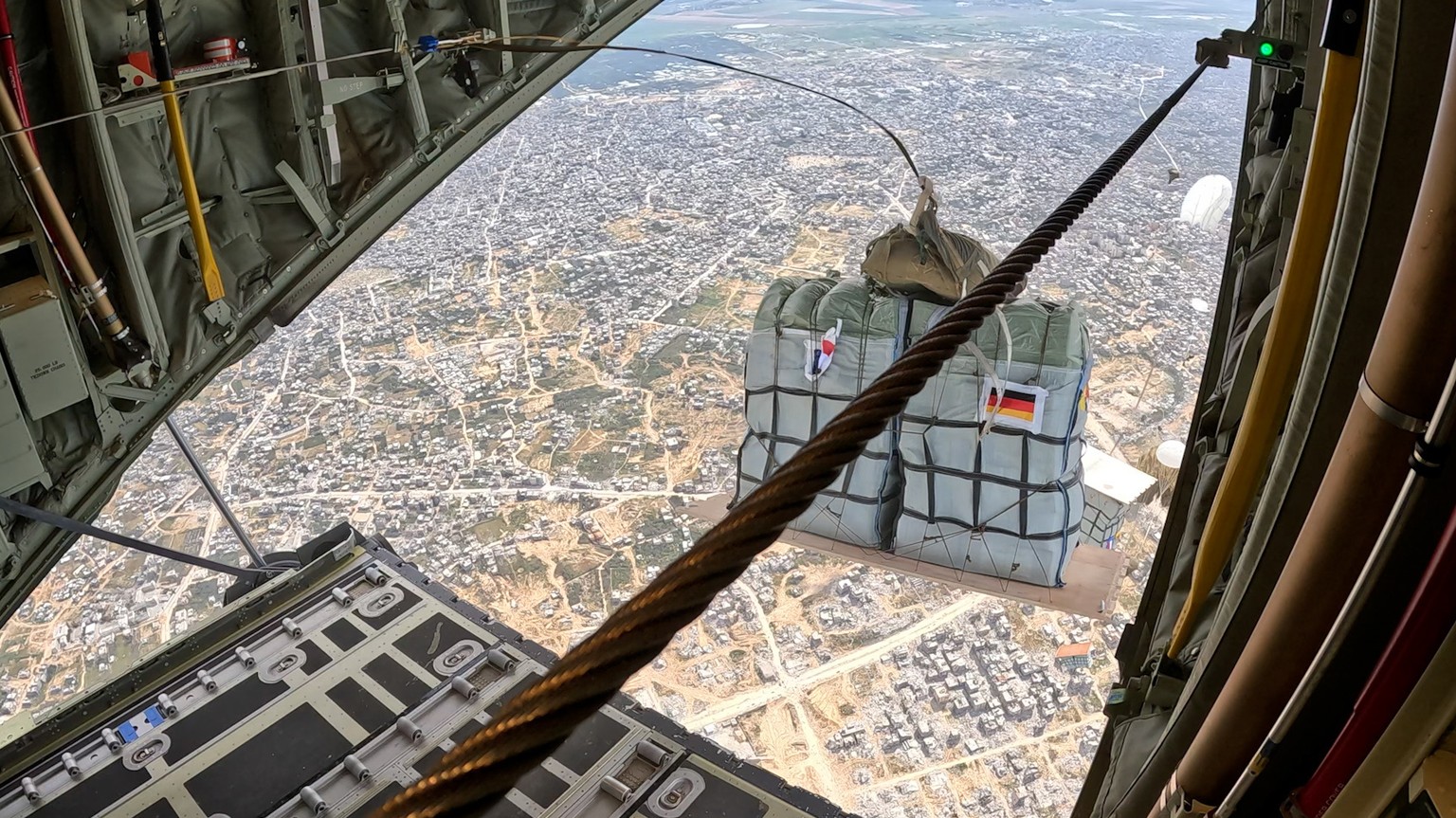 epa11224217 A handout photo made available by German Armed Forces shows a C-130 of the bi-national German-French squadron &#039;Rhein/Rhin&#039; drops relief supplies over the Gaza Strip, 16 March 202 ...