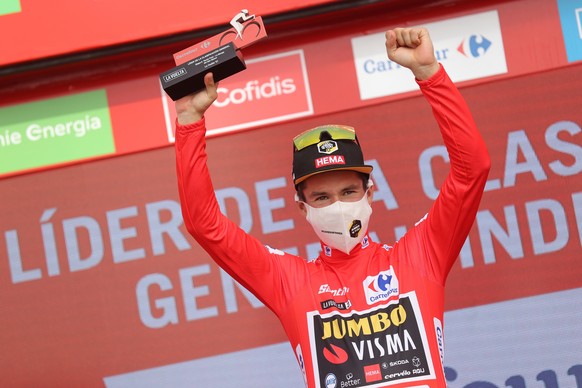 epa09423690 The overall leader, Slovenian Primoz Roglic, of Jumbo-Visma, wearing the red maillot on the podium after the 8th stage of the Spanish Cycling Vuelta, a 173,7 km-long race between Santa Pol ...