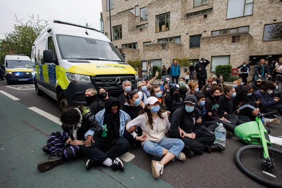 epa11314571 Demonstrators form a blockade around police vans and a coach which was due to remove asylum seekers from a hotel in Peckham, London, Britain, 02 May 2024. Protesters claim the bus was arra ...