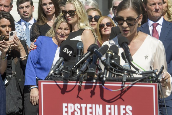 Anouska De Georgiou, center, embraces Danielle Bensky, left, as Marina Lacerda, right, speaks during a news conference regarding the release of the Jeffrey Epstein files, on Capitol Hill, Wednesday, S ...