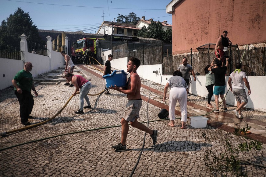 epa10064087 Inhabitants battle a forest fire in Canecas, outskirts of Lisbon, Portugal, 10 July 2022. Portugal&#039;s President warned that the risk of fires will reach a peak in the next few days and ...