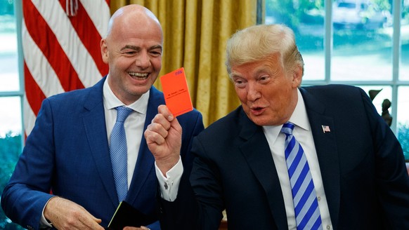 FILE - President Donald Trump holds up a red card during a meeting with FIFA president Gianni Infantino in the Oval Office of the White House, Tuesday, Aug. 28, 2018, in Washington. (AP Photo/Evan Vuc ...