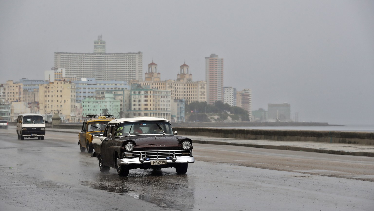 epa10825970 People drive vehicles in the rain, at the Malecon in Havana, Cuba, 28 August 2023. The western end of Cuba braces this 28 August on alert for the passage of tropical storm Idalia, which co ...