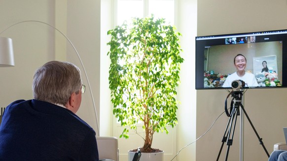 epa09597016 A handout photo made available by the International Olympic Committee (IOC) website shows IOC President Thomas Bach holding a video call with Chinese tennis star Peng Shuai on 21 November  ...