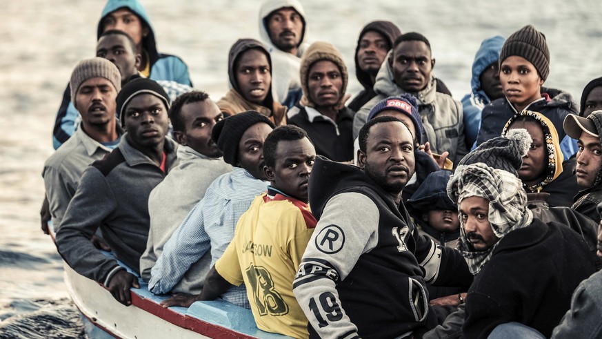 In this Nov. 22, 2017 photo provided Thursday, Nov. 23, 2017, migrants on a small wooden boat wait to be rescued by the German non-profit organization Sea Watch, in the central Mediterranean Sea. Acco ...